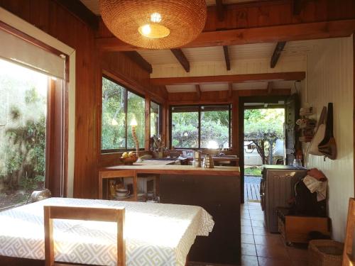a kitchen with a table and a sink and some windows at Casa del Estero in Pucón