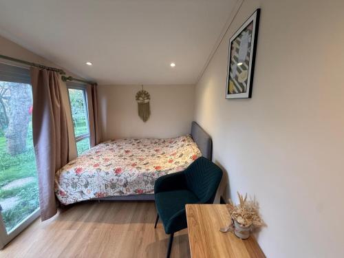 a bedroom with a bed and a table and a chair at Tiny home OR Chalet - with toilet & shower room in separate outbuilding in Nottingham
