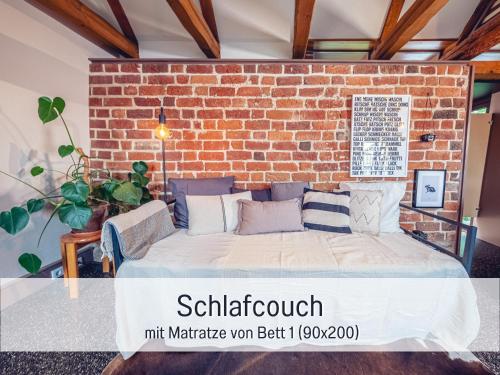 a bed in a room with a brick wall at Molly Moll - Mini Ferienhaus in Kyritz, einer charmanten Stadt im Herzen von Brandenburg in Kyritz