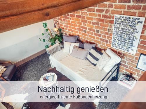a couch against a brick wall with the words narrating genebenenberg interactive furniture at Molly Moll - Mini Ferienhaus in Kyritz, einer charmanten Stadt im Herzen von Brandenburg in Kyritz