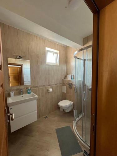 a bathroom with a toilet sink and a shower at Амон Ра 2 in Primorsko