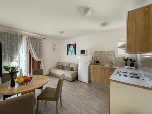 a kitchen and living room with a table and a couch at Villa ARINA - Apartments 20 m from Beach, Tucepi in Tučepi
