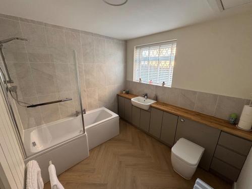 a bathroom with a shower and a toilet and a sink at 2 Bedroom Bungalow by the Arches in Earlestown