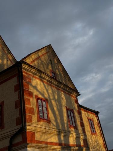 a building with red windows on the side of it at Zámek Ostrolov in Ostrolovský Újezd