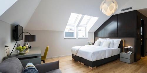 a bedroom with a large bed and a couch at Livris Hotel in Zagreb