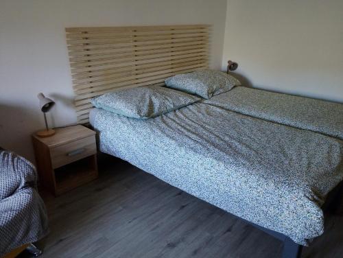 a bedroom with a large bed and a night stand at Apartmán KPS in Kalameny