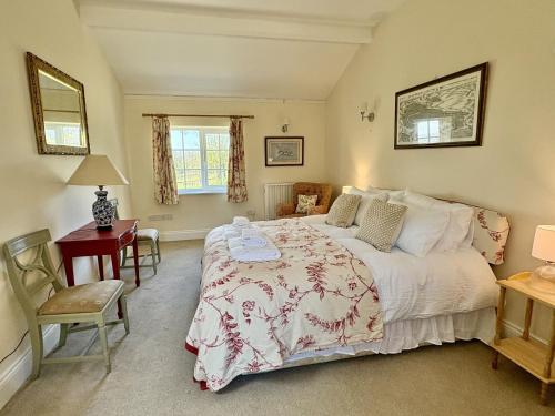 a bedroom with a bed and a desk and a chair at Blackmoor View Cottage in Sherborne