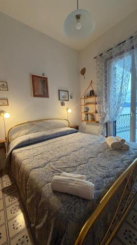 a large bed in a bedroom with a window at La casa del Capitano, l'uomo e il mare ... in Lipari