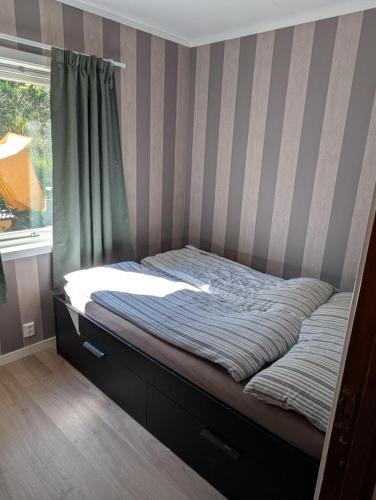 a bed in a room with a window at Rasteplassen in Stordalen