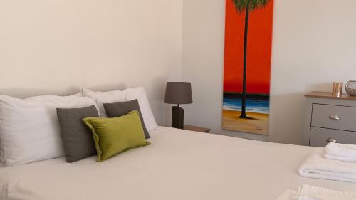 a bedroom with a white bed with a green pillow at Converted Barn Studio with Private En-Suite in Horspath