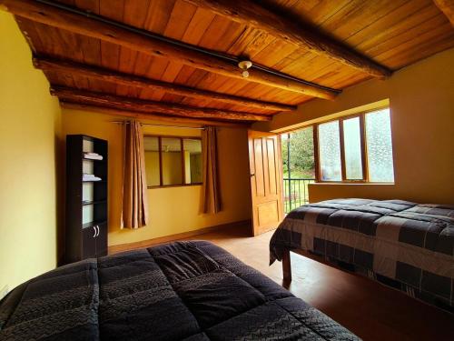 a bedroom with a bed and a wooden ceiling at Casa Rumiwillka in Urubamba