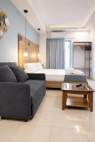 a living room with a bed and a couch at Anemone Suites in Georgioupolis