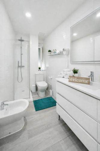 a white bathroom with a sink and a toilet at BLUE PLATAN Apartment in Salou