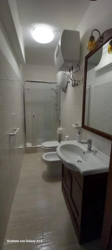 a bathroom with two toilets and a sink and a mirror at Kylix Home in Campobasso