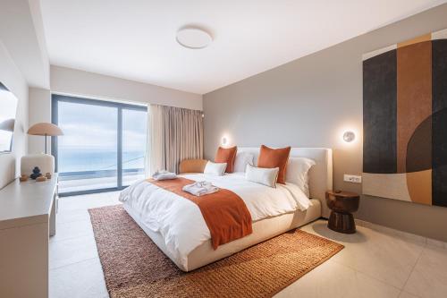 a bedroom with a large bed and a large window at Villa Erifyli in Aghia Marina