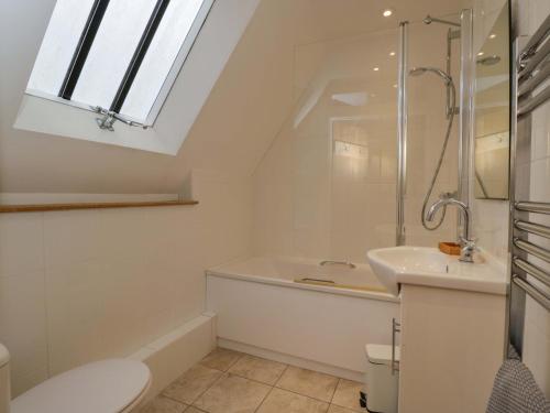 a bathroom with a shower toilet and a sink at Stanbridge Cottage in Malmesbury