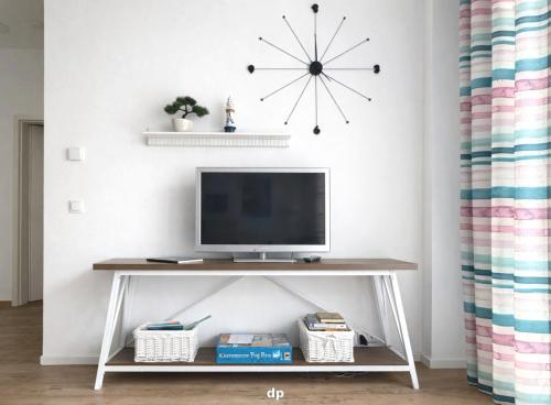 a tv on a console table in a living room at DUENENROSE App Nr 03 max 3 Pers in Dierhagen