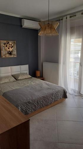 a bedroom with a bed and a large window at Capital Apartment kilkis in Kilkis
