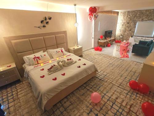 a bedroom with a bed with red hearts and balloons at روز بيلا 1 Rosa Bella in Al Jināh