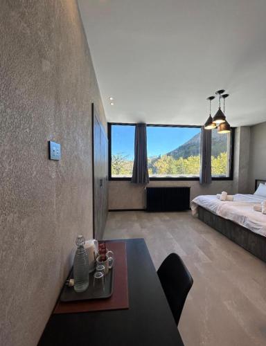 a bedroom with a bed and a table in a room at Laklouk Village Vacances in Jbeil