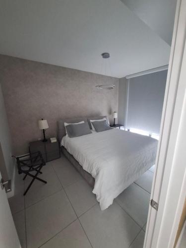 a bedroom with a large white bed and a window at Bonito doral in Miami
