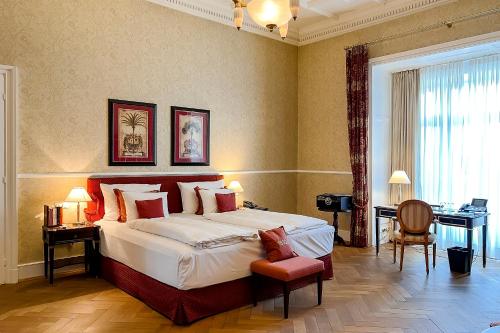 a large bedroom with a large bed and a desk at Villa Rothschild, Autograph Collection in Königstein im Taunus