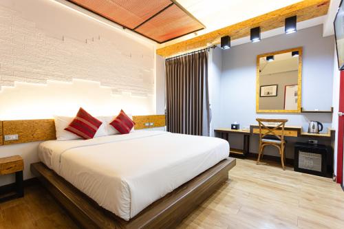 ein Hotelzimmer mit Bett und Schreibtisch in der Unterkunft Ps Sriphu Hotel in Hat Yai