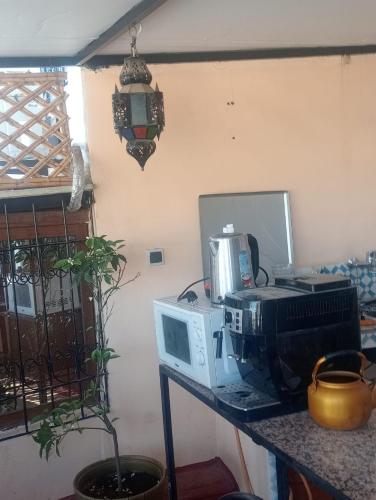 a kitchen counter with a microwave and a computer on a table at Esc 3 in Fez
