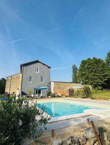 a house and a swimming pool in front of a building at La hulotte de Labarthe in Mazères