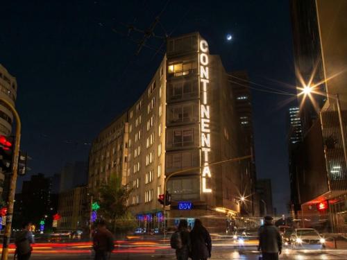 a tall building with a sign on it at night at Continental Aparthotel Bogotá - Aparta Suite in Bogotá