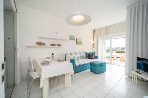 a living room with a white table and a couch at Residence Scoglietto 50 in Punta Ala