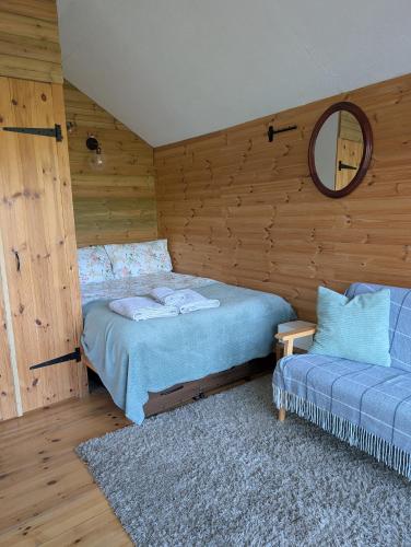 a bedroom with two beds and a mirror on the wall at Dryw bach glamping hut in Llandeilo