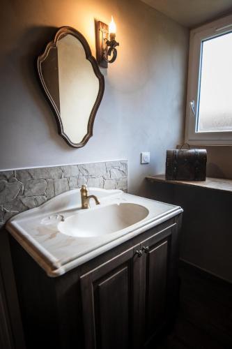 a bathroom with a sink and a mirror on the wall at Le Logis des Seigneurs in La Flocellière