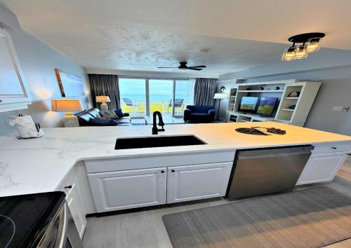 a kitchen with a sink and a living room at Just Updated Wyndham Ocean Walk Resort Daytona Beach 1606 One Bedroom Resort Condo Oceanfront in Daytona Beach