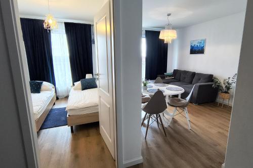 a living room with a couch and a table at Nowy w centrum 2 in Giżycko