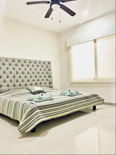 a large bed in a room with a ceiling fan at Ph and apartments riviera Maya in Playa del Carmen