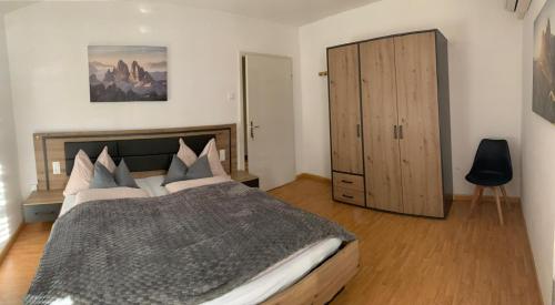 a bedroom with a large bed and a cabinet at Garni Guflhof in Caldaro