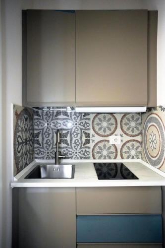 a kitchen with a sink and tiles on the wall at Luxury Suite ATHENA - MINERVA in Reggio di Calabria