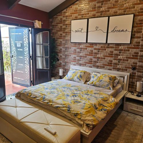 a bed in a room with a brick wall at Penthouse in Le Hamiz