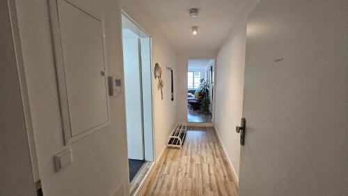 a hallway with a door and a chair on a wooden floor at Studio - Charmant, Gemütlich & Zentral in Landsberg am Lech