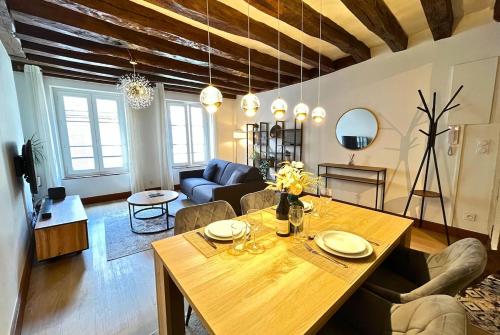 a living room with a table and a couch at Au Charme Amboisien - Centre-ville et climatisé in Amboise