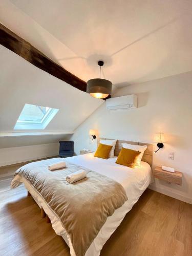 a bedroom with a large white bed with a window at Au Charme Amboisien - Centre-ville et climatisé in Amboise