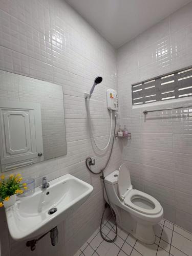 a bathroom with a shower and a toilet and a sink at AN Airport Guesthouse in Nai Yang Beach
