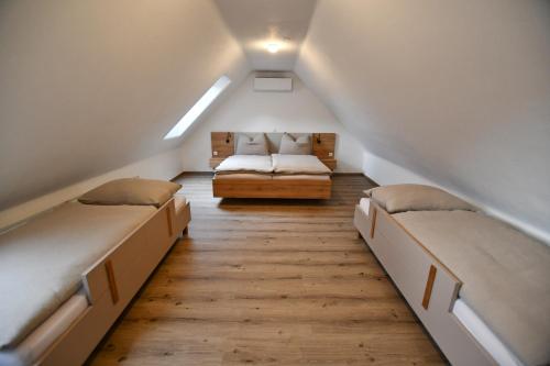 a attic room with two beds and a couch at Wohlfühl Apartments am Hof Rapotz in Leutschach