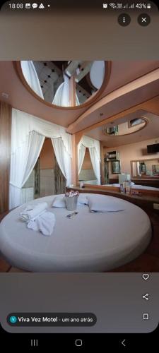 a large white bed in a room with a circular ceiling at Motel Viva Vez in Canoas