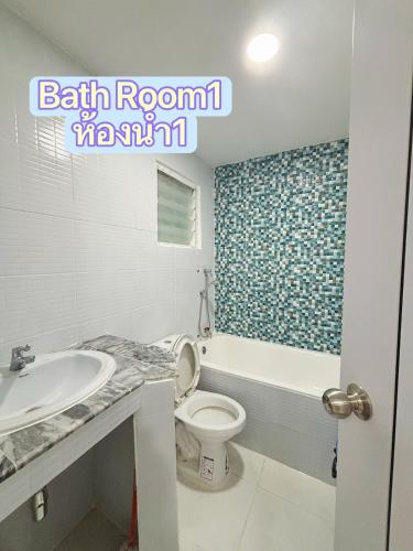 a bathroom with a toilet and a sink at Whitebeach Cottage in Chon Buri