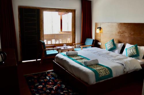 a bedroom with a large bed and a window at The Kun in Leh