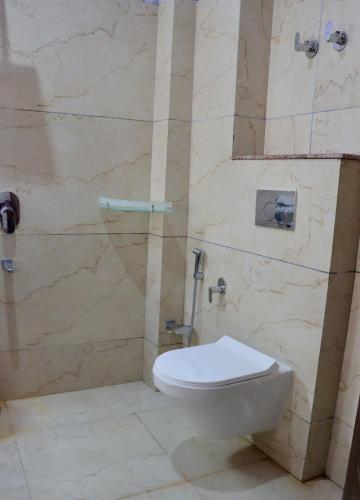 a bathroom with a toilet and a stone wall at The Kun in Leh