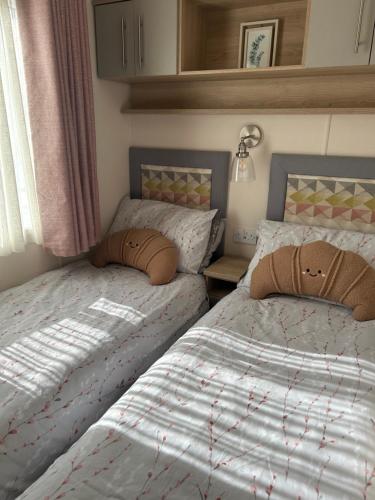 two beds sitting next to each other in a bedroom at Home from Home at the Hendersons Caravan in Kilwinning