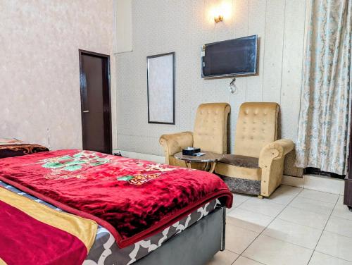 a bedroom with a bed and a flat screen tv at Royal Fort Executive Hotel Gulberg in Lahore